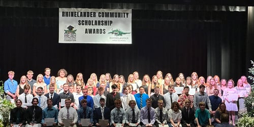 Students line up on stage for a photo after receiving local area scholarships